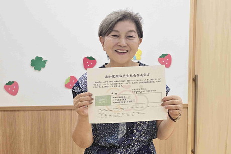 「高知家地域共生社会推進宣言書」を持つ支部長の谷本さん